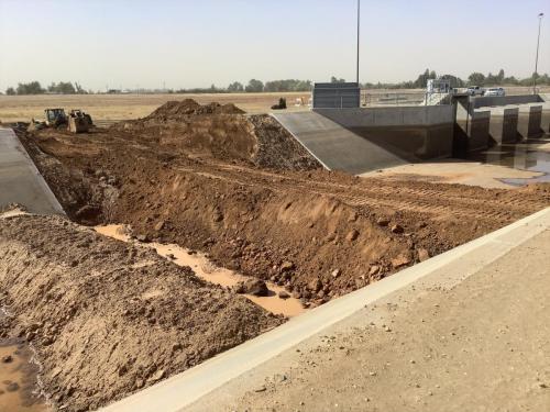 soil berm constructed across Fresno Canal to keep nuissance water from entering the work area