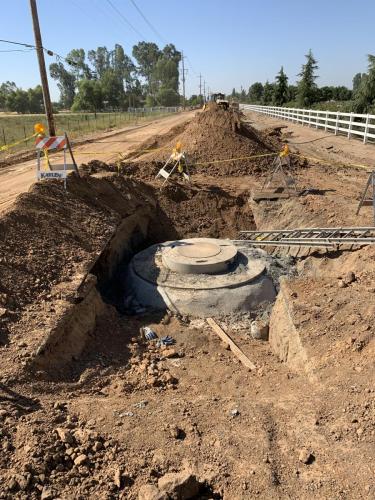 Open storm drain trench with unfinished manhole