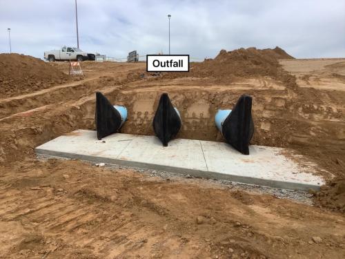 completed dischage piping with Tide Flex Rubber Duckbill Checkvalves sitting above a concrete splash pad.